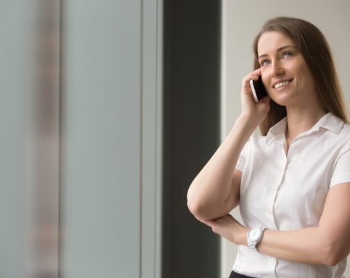 Smiling confident businesswoman talking on cellphone. Beautiful woman in formal wear calling from mobile phone. Female entrepreneur has pleasant business conversation, successful phone negotiations